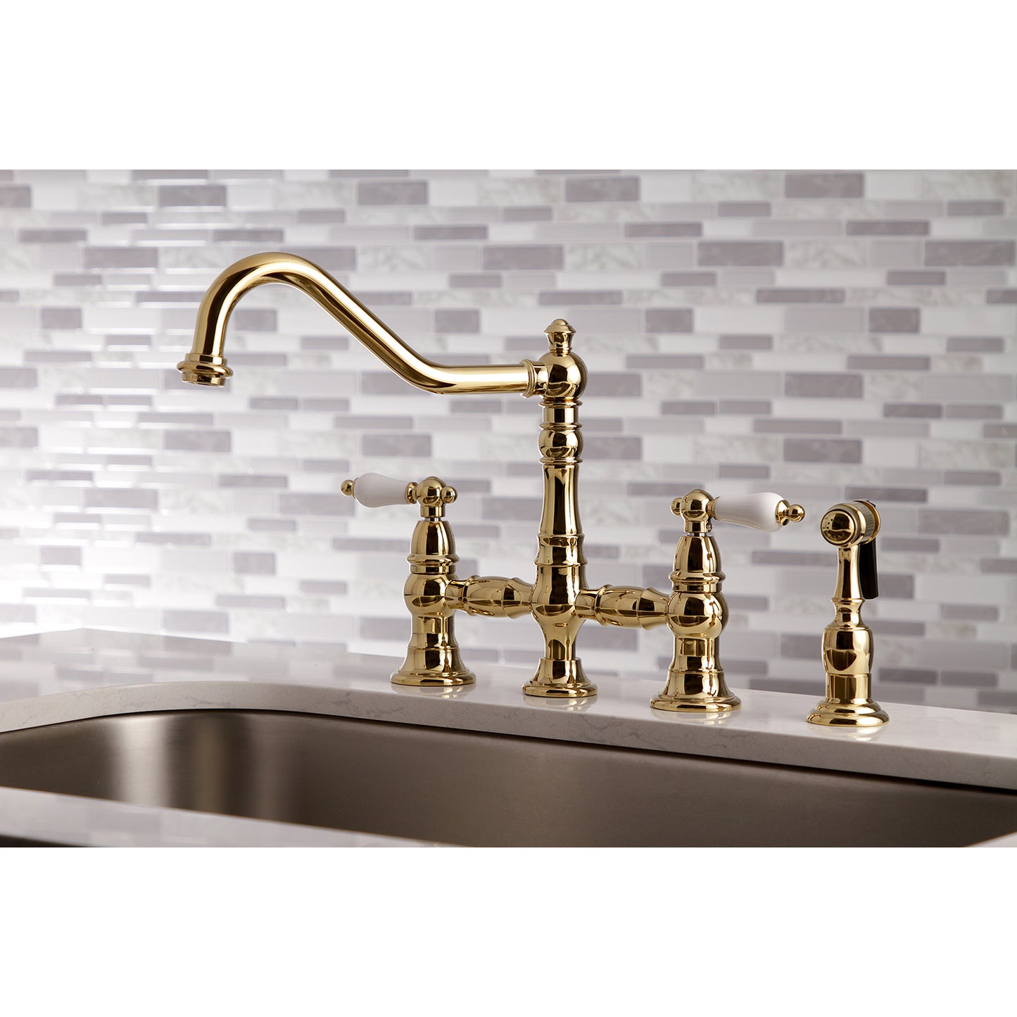 Kingston KS3277PLBS Restoration Bridge Kitchen Faucet with Brass Sprayer, Brushed Brass on a stylish kitchen countertop.