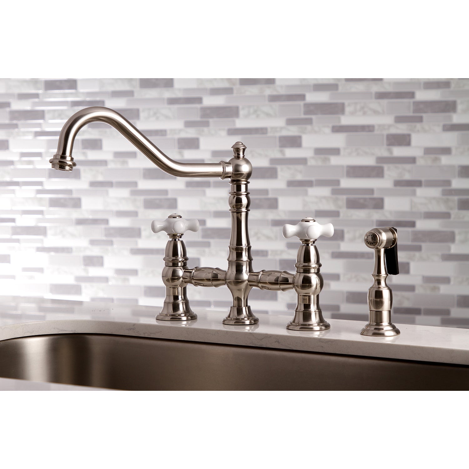 Kingston KS3277PXBS Restoration Bridge Kitchen Faucet with Brass Sprayer, Brushed Brass on a kitchen sink.