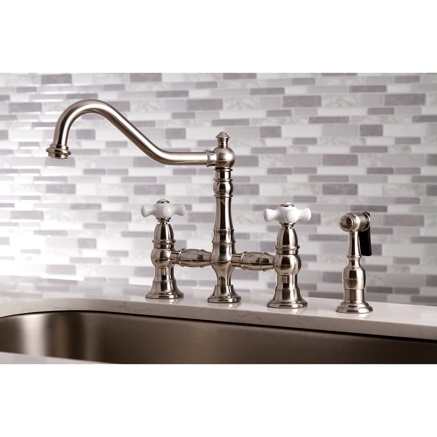 Kingston KS3277PXBS Restoration Bridge Kitchen Faucet with Brass Sprayer, Brushed Brass on a kitchen sink.