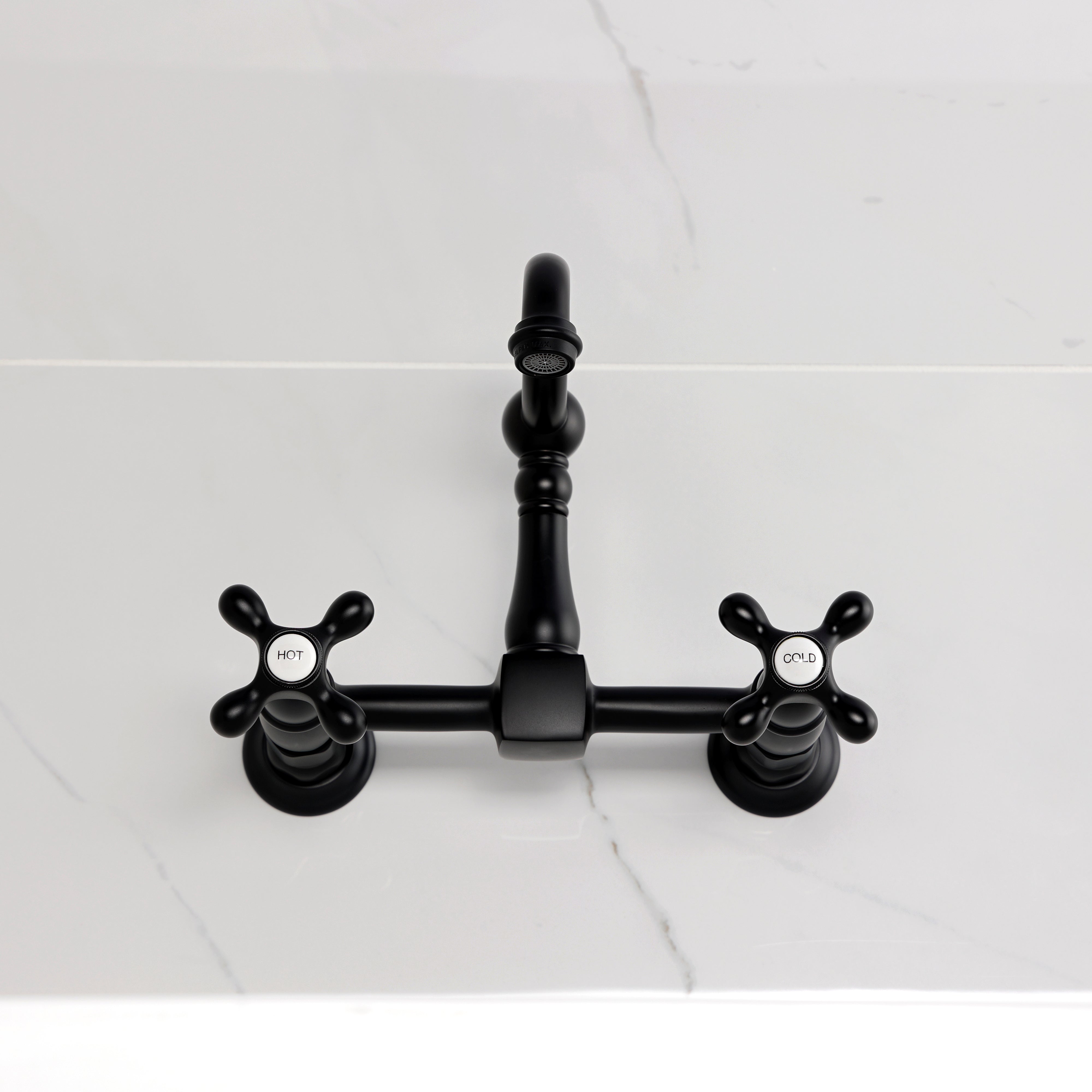 Kingston KS2443AX Heritage Two-Handle Wall Mount Bridge Kitchen Faucet, Antique Brass on a marble countertop