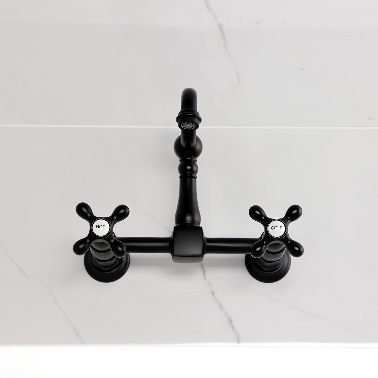 Kingston KS2443AX Heritage Two-Handle Wall Mount Bridge Kitchen Faucet, Antique Brass on a marble countertop