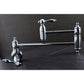 Kingston Brass KS3103TAL Tudor Wall Mount Pot Filler Faucet, Antique Brass in a chrome finish on a counter.