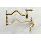 Kingston Brass KS2107BAL Heirloom Wall Mount Pot Filler Faucet, Brushed Brass on a marble background.