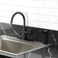 Kingston Brass KSD2433RNK Levante Single-Handle Kitchen Faucet, Antique Brass on black countertop with side spray.