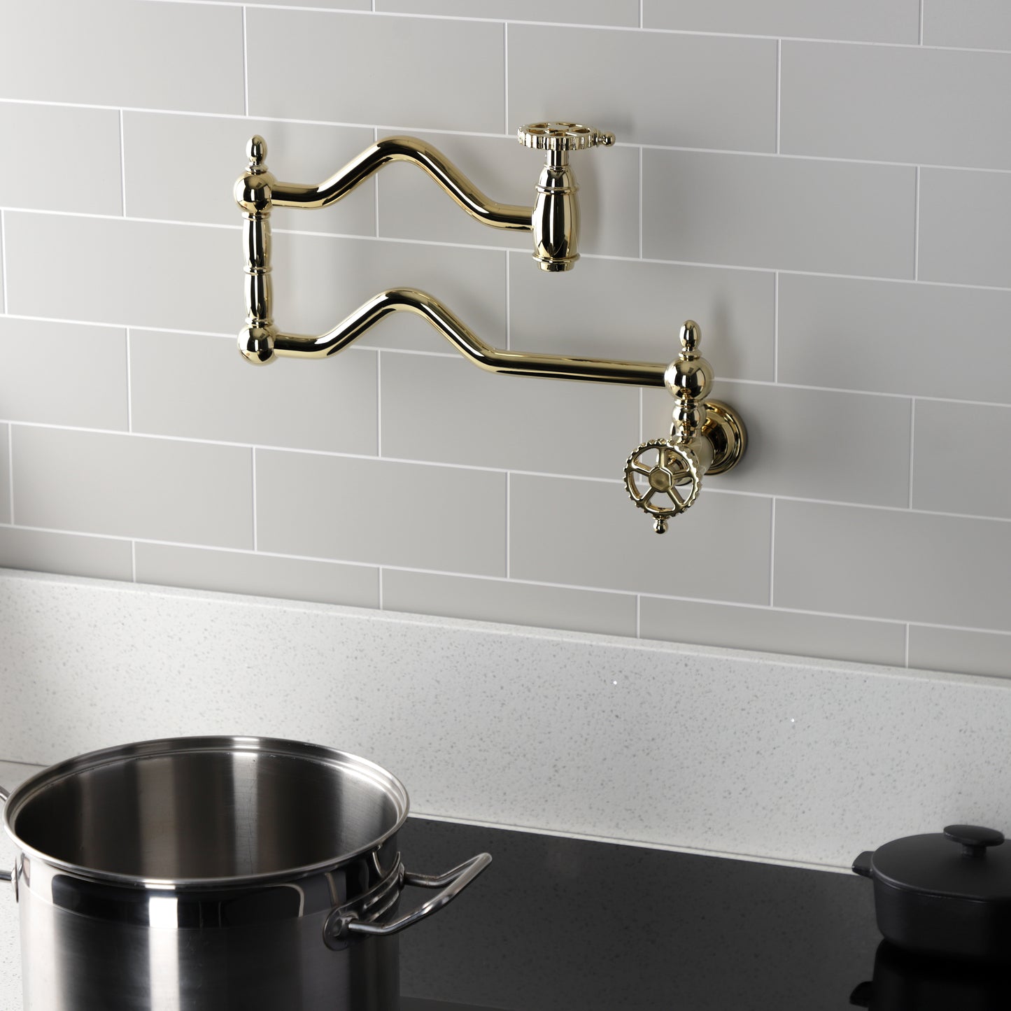 Kingston Brass KS2107CG Fuller Wall Mount Pot Filler Faucet, Brushed Brass installed above a pot on a modern kitchen countertop.
