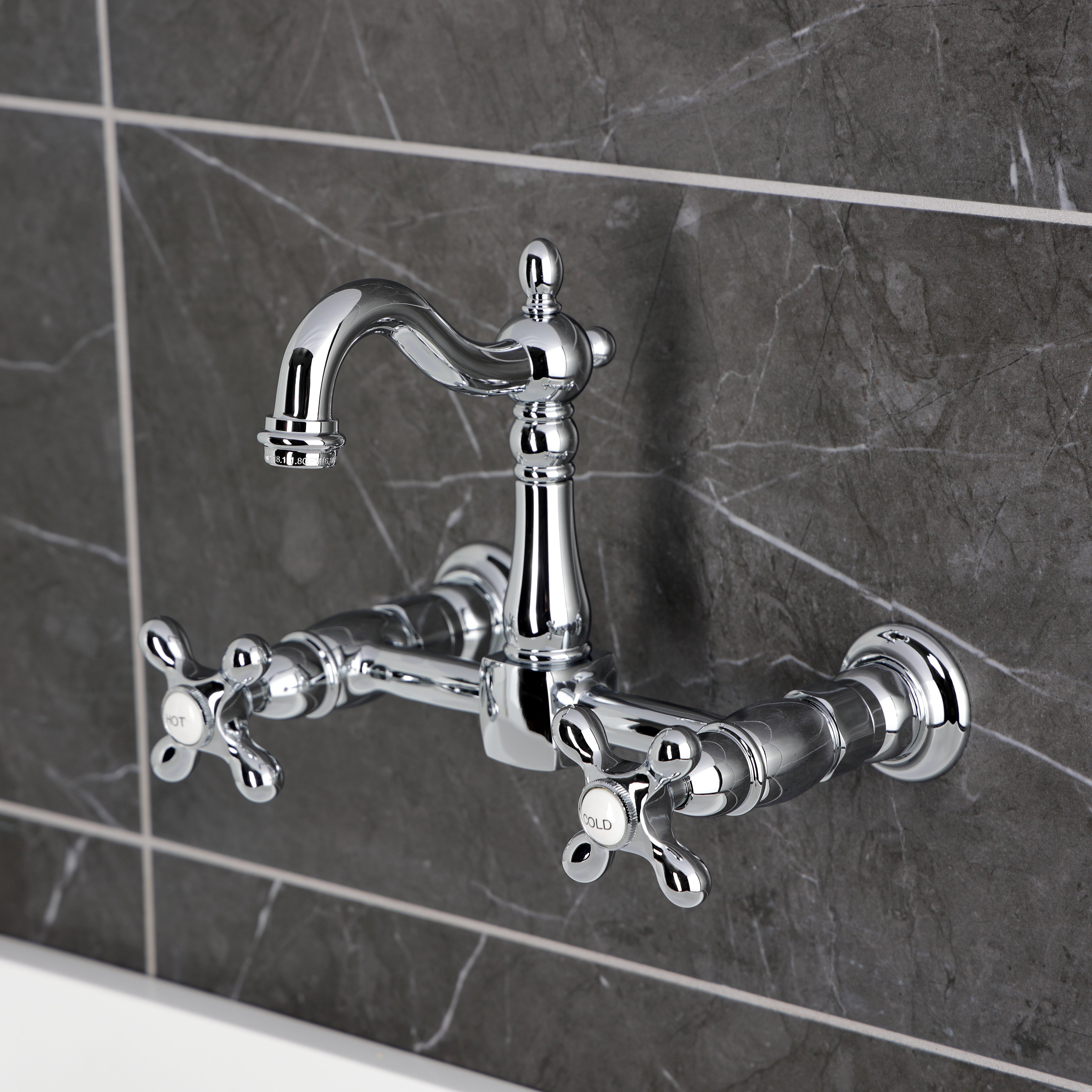 Kingston KS2443AX Heritage Two-Handle Wall Mount Bridge Kitchen Faucet, Antique Brass on a modern gray background