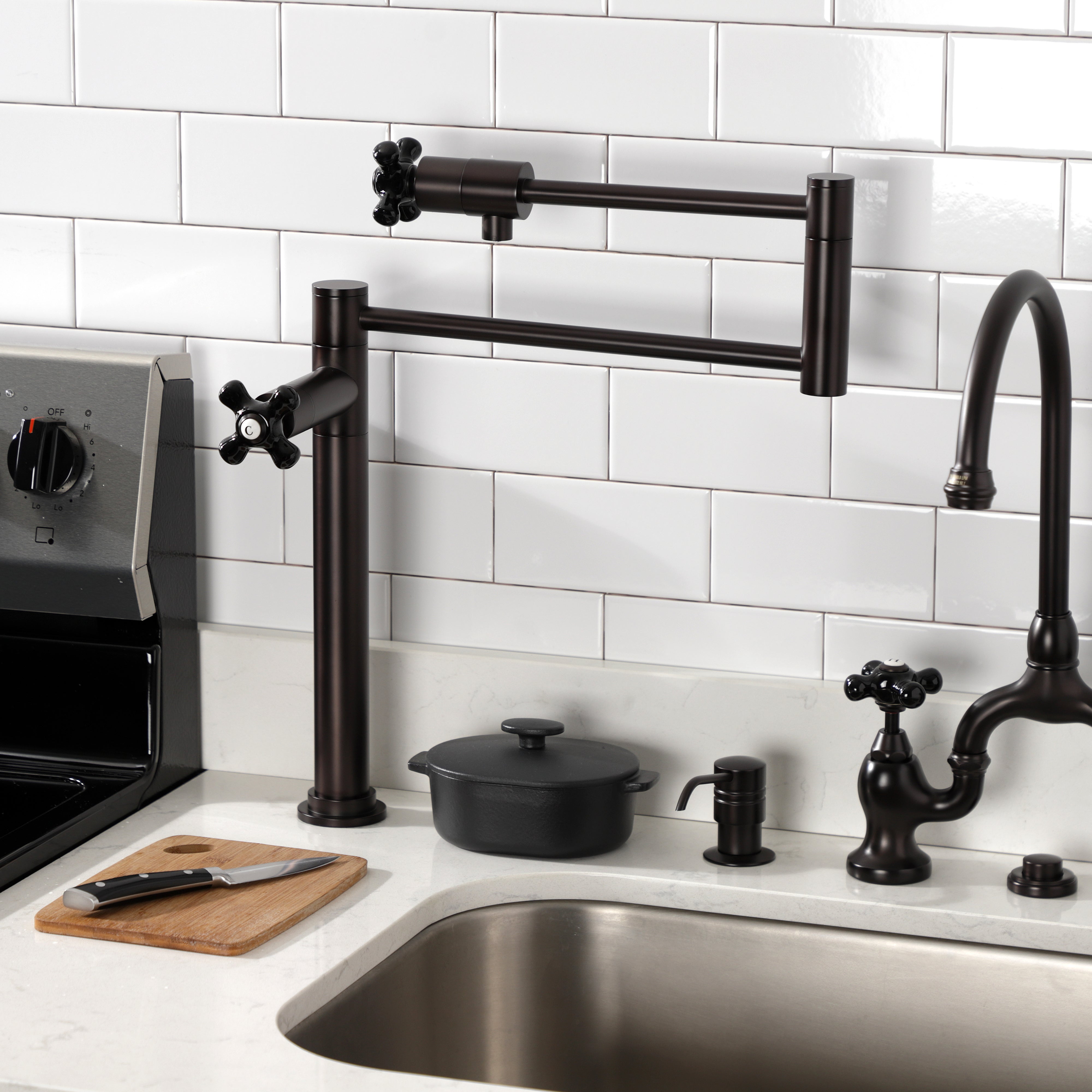 Kingston Brass KS4703PKX Duchess Deck Mount Pot Filler Faucet, Antique Brass in kitchen setting with black porcelain handles.