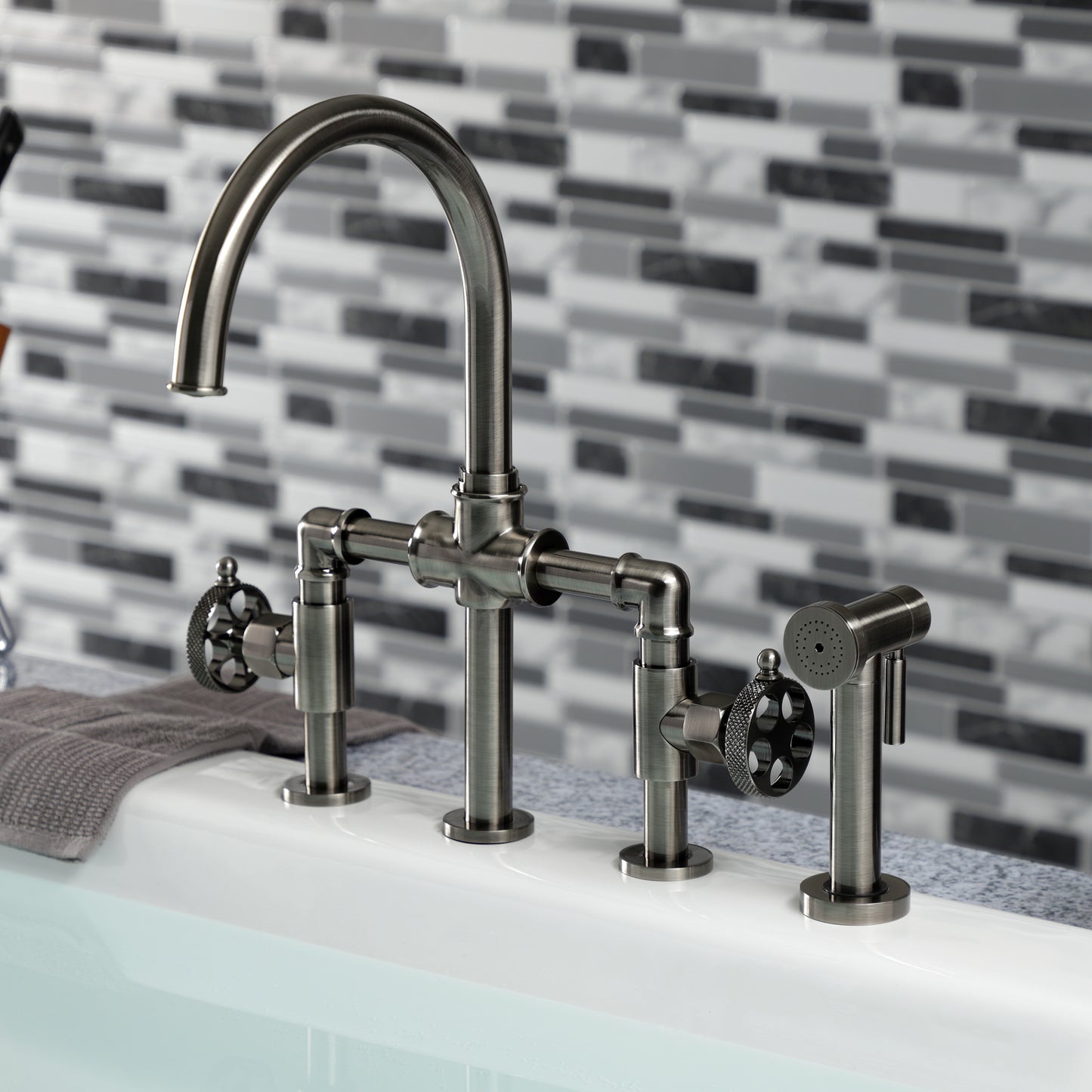 Kingston KS2333RKX Webb Knurled Handle Bridge Kitchen Faucet with Brass Sprayer, Antique Brass in modern kitchen setting.