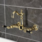 Kingston KS2443PKL Duchess Two-Handle Wall Mount Bridge Kitchen Faucet, Antique Brass on a modern grey tiled wall.