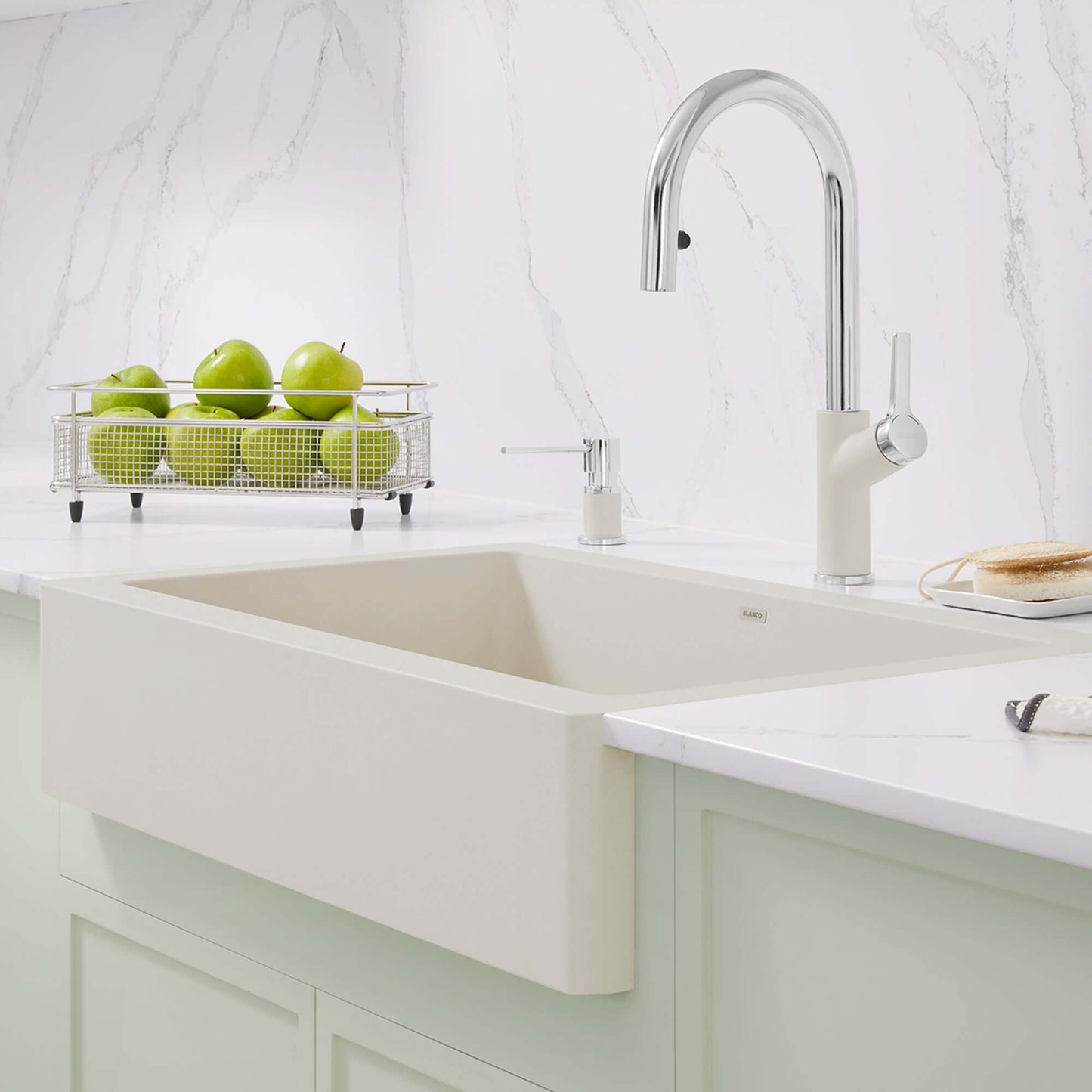 BLANCO VINTERA 30" SILGRANIT Single Bowl Farmhouse Sink with stylish chrome faucet and green apples in a basket.