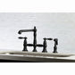 Kingston KS7277ALBS English Country Bridge Kitchen Faucet with Brass Sprayer, Brushed Brass in a modern kitchen setting.
