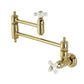 Kingston Brass KS310PXAC Restoration Wall Mount Pot Filler Faucet, Antique Copper with polished brass finish and white knobs.