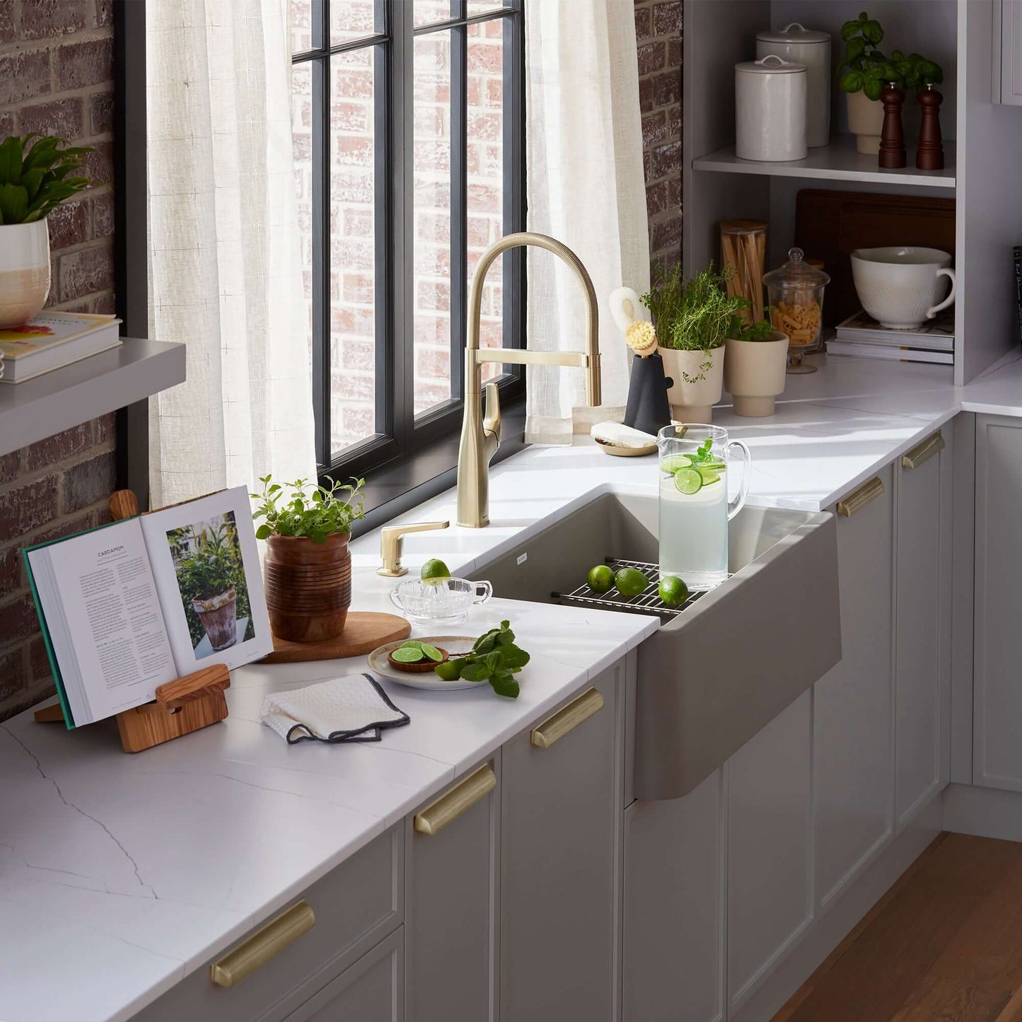 BLANCO Ikon SILGRANIT 33" Single Bowl Apron-Front Farmhouse Sink in a modern kitchen setting with fresh limes and a book.