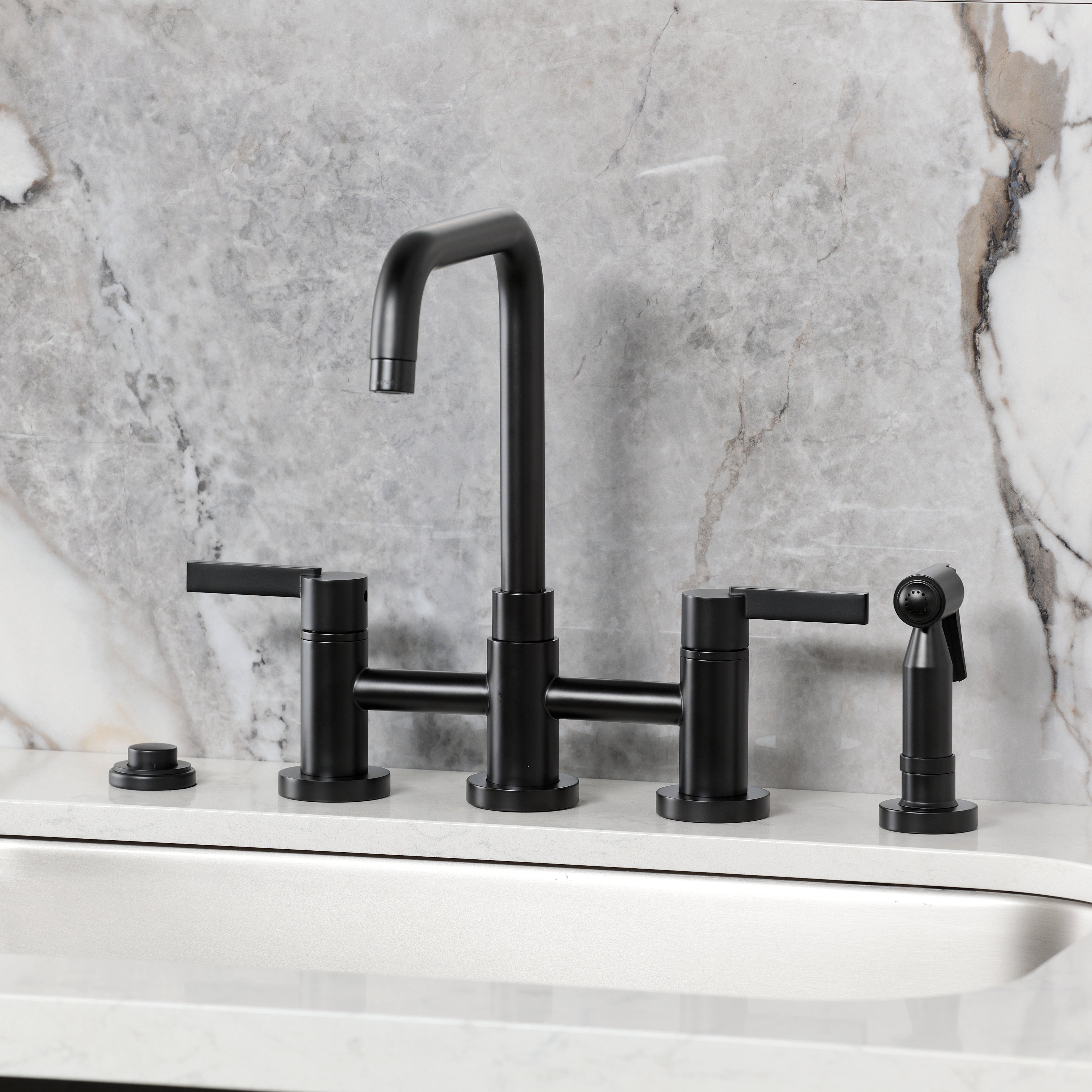 Kingston KS8287CTLBS Continental Bridge Kitchen Faucet with Brass Sprayer, Brushed Brass on a marble countertop.