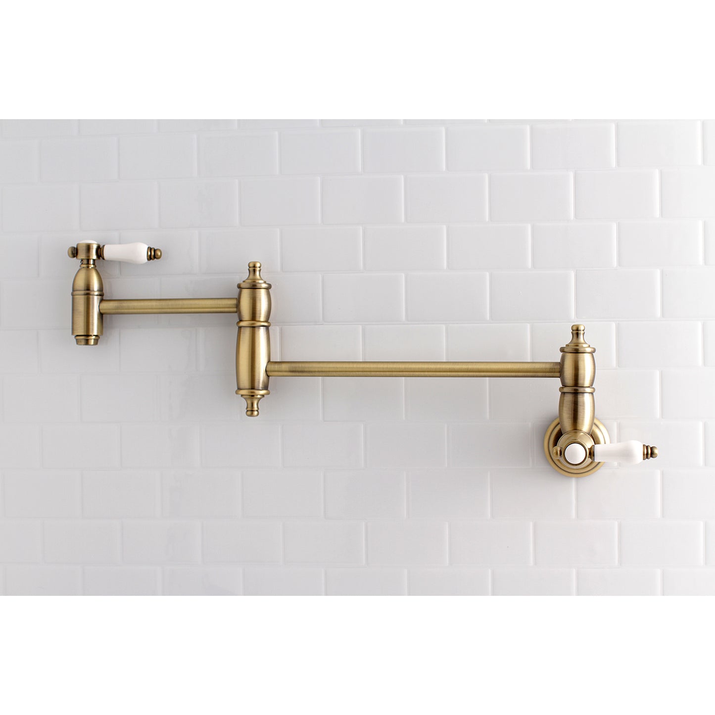 Kingston Brass KS3103BPL Bel-Air Wall Mount Pot Filler Faucet, Antique Brass on a white tiled backdrop.