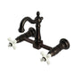 Kingston KS2443PX Heritage Two-Handle Wall Mount Bridge Kitchen Faucet, Antique Brass with porcelain cross handles.