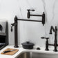 Kingston Brass KS3708TAL Tudor Deck Mount Pot Filler Faucet, Brushed Nickel on countertop with black cookware.