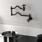 Kingston Brass KS2107CG Fuller Wall Mount Pot Filler Faucet, Brushed Brass mounted with a pot on stove.