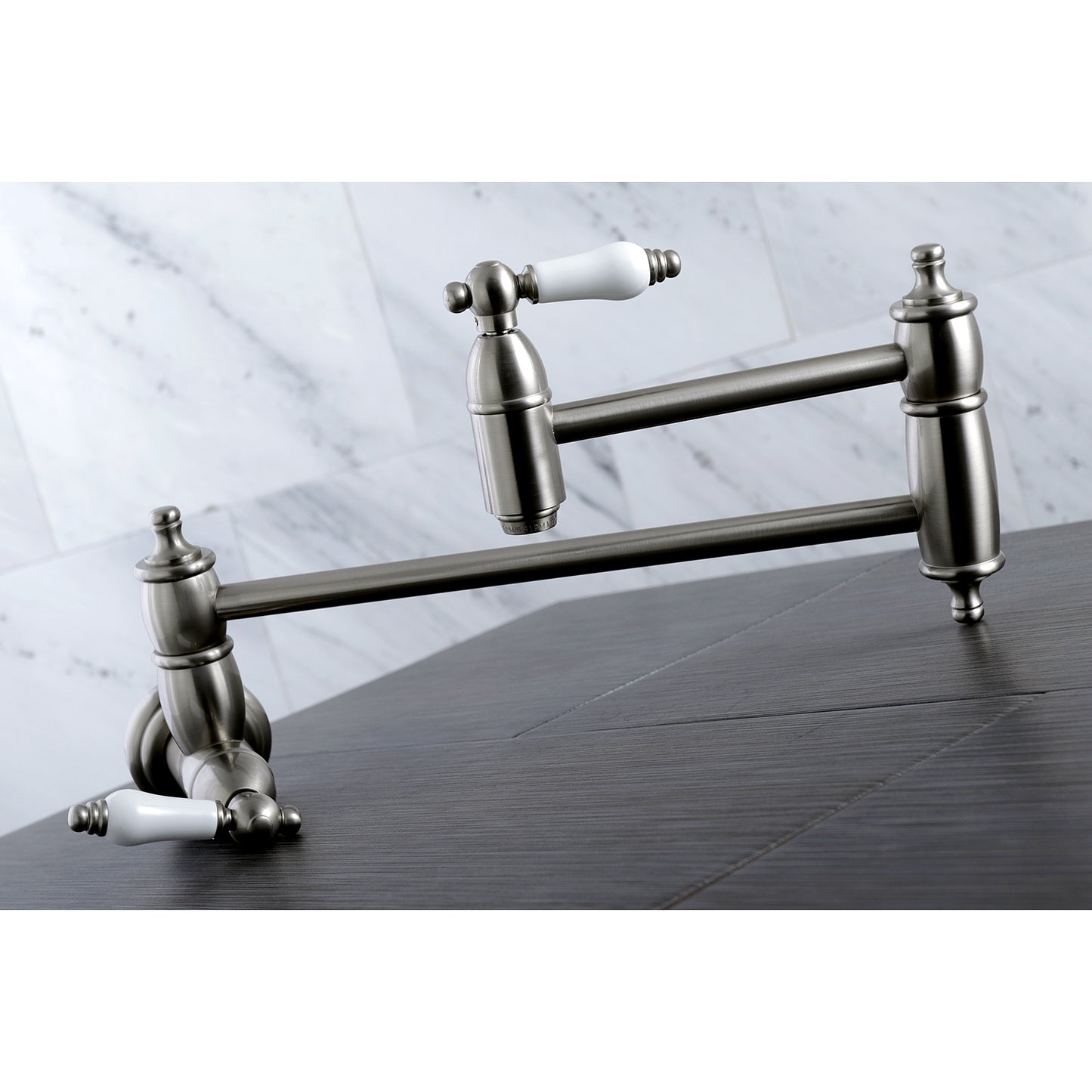 Kingston Brass KS3103PL Restoration Wall Mount Pot Filler Faucet, Antique Brass on a wooden countertop.