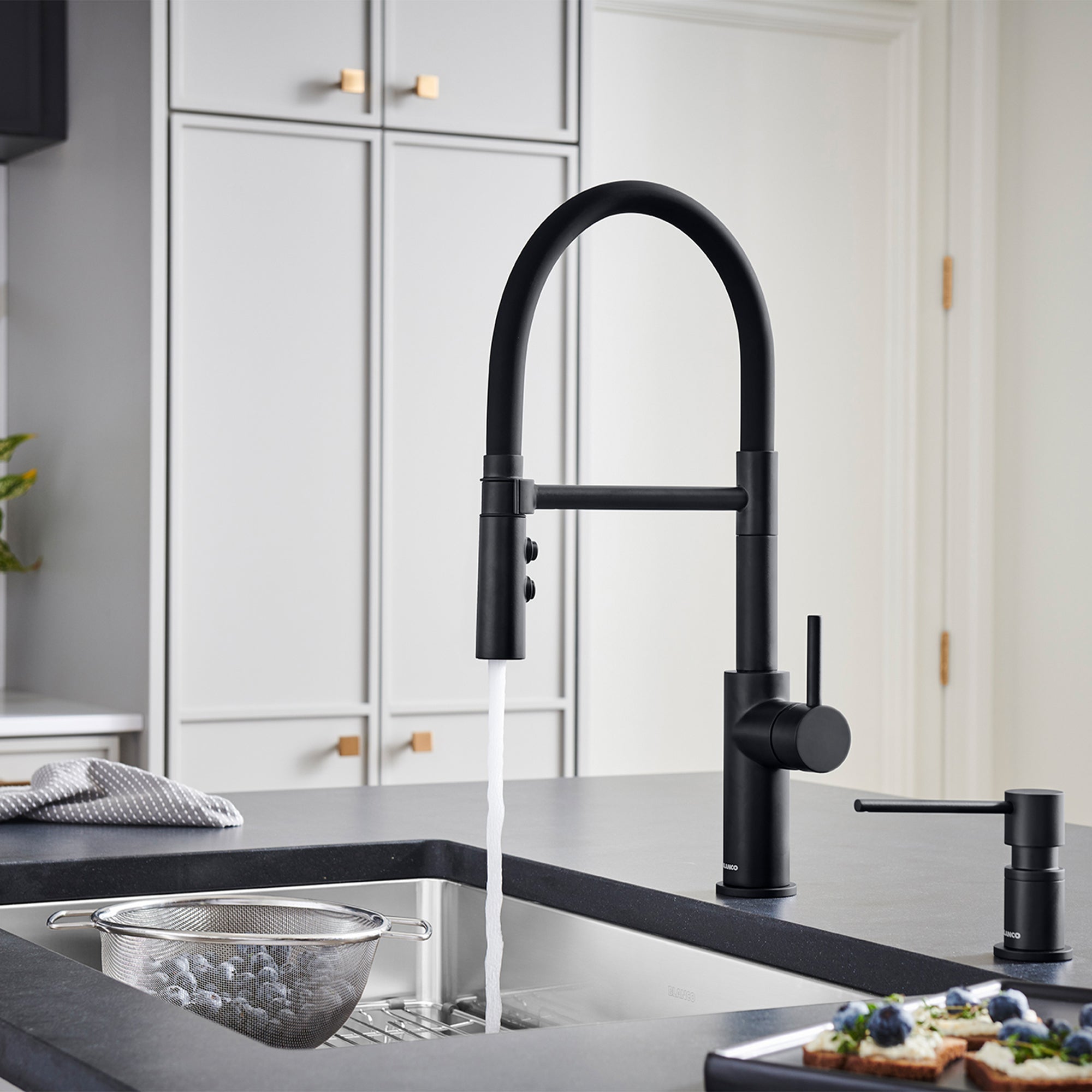 BLANCO Catris Flexo Semi-Pro Pull-Down Dual-Spray Kitchen Faucet in modern black kitchen setting with running water.
