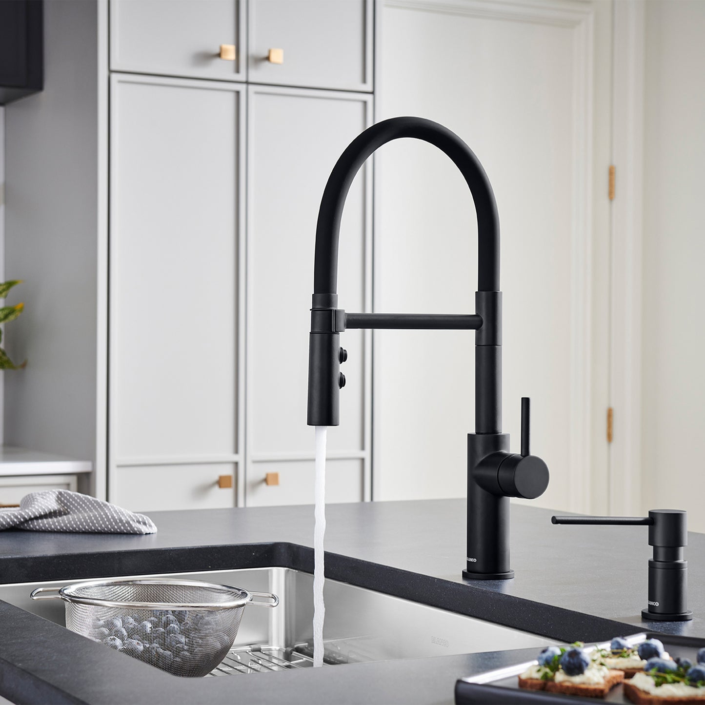 BLANCO Catris Flexo Semi-Pro Pull-Down Dual-Spray Kitchen Faucet in modern black kitchen setting with running water.