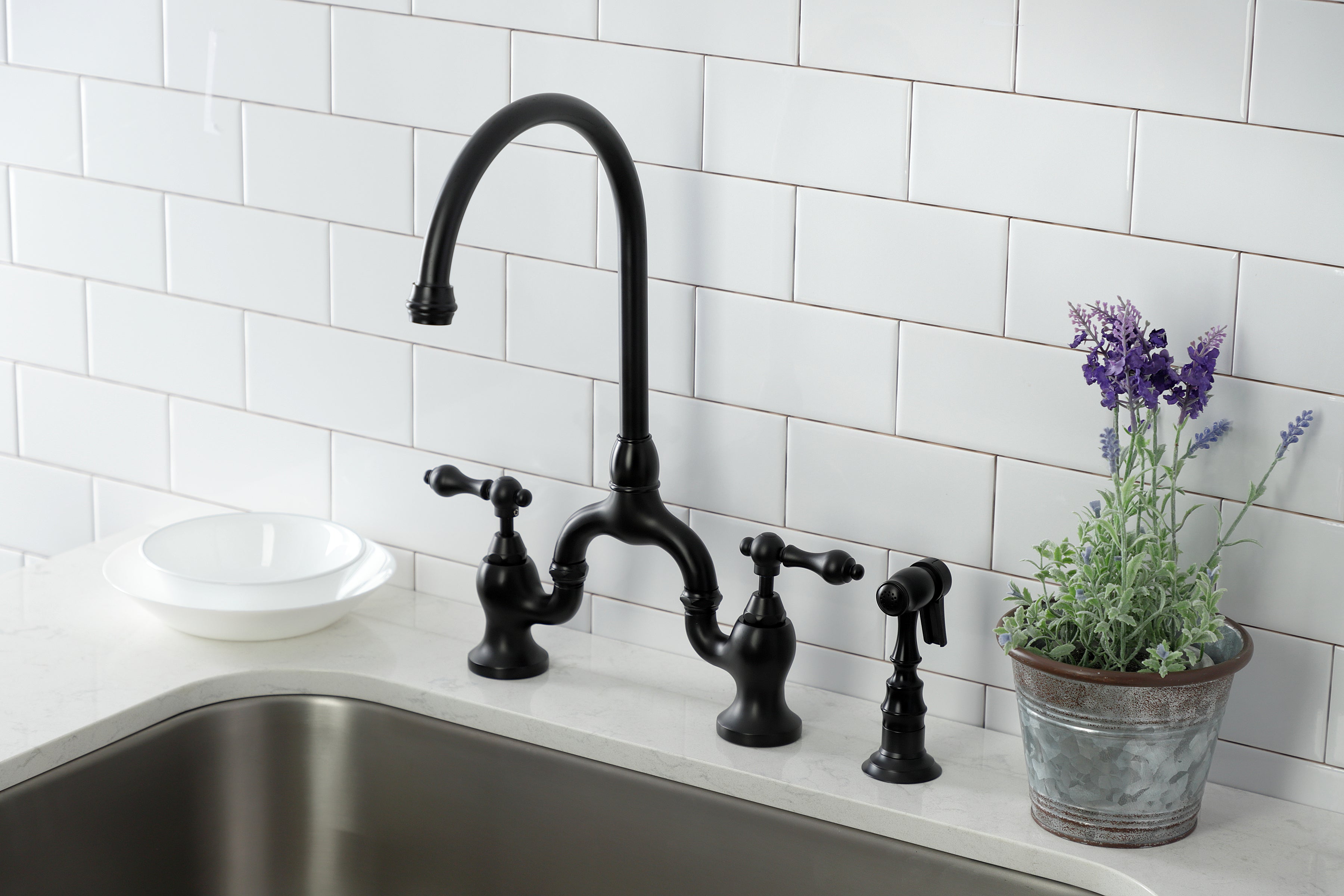 Kingston KS7793ALBS English Country Bridge Kitchen Faucet with Brass Sprayer, Antique Brass in a modern kitchen setting.