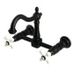 Kingston KS1263PX Heritage Two-Handle Wall Mount Bridge Kitchen Faucet, Antique Brass with black finish and white cross handles.