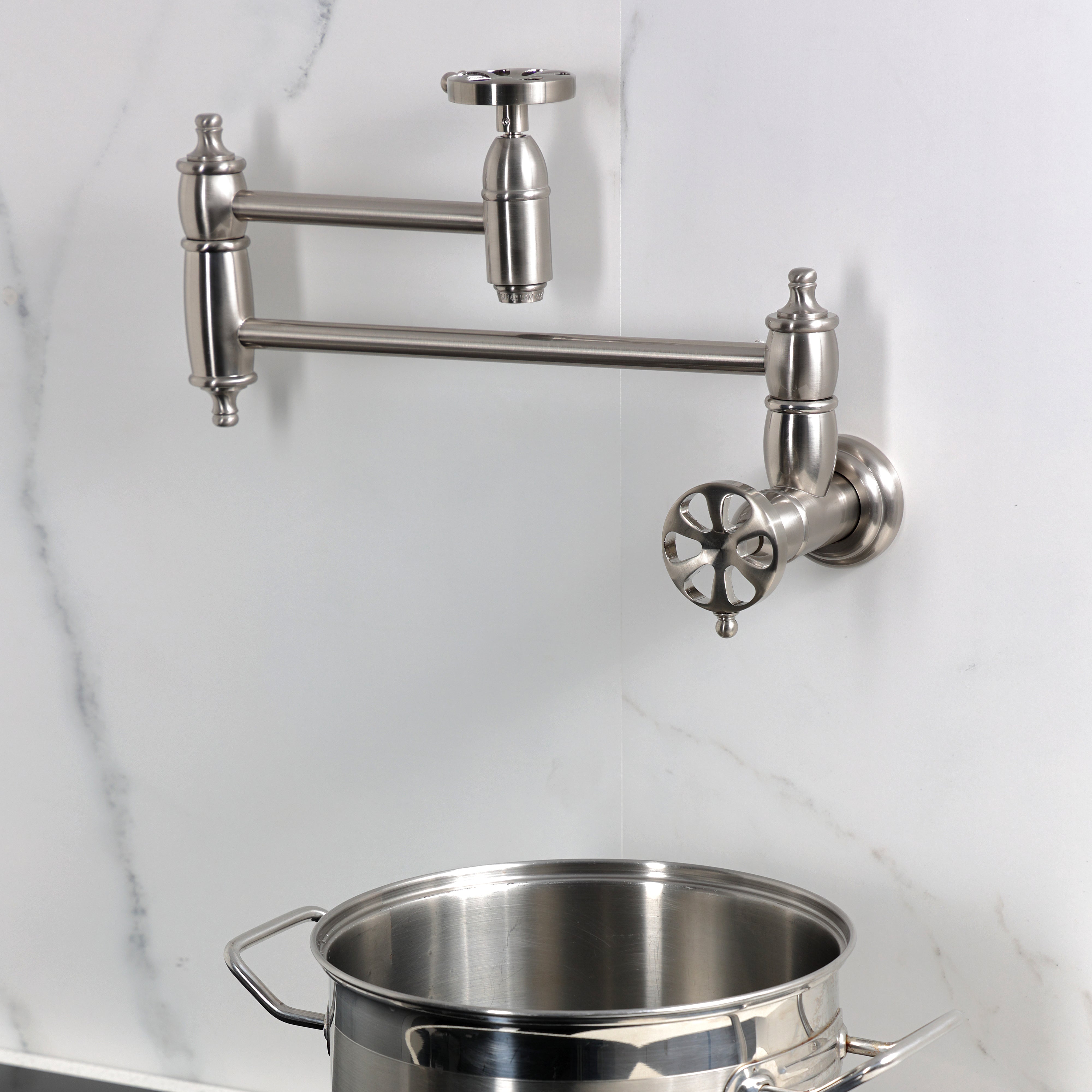 Kingston Brass KS3103RX Belknap Wall Mount Pot Filler Faucet, Antique Brass with swing arms and pot.