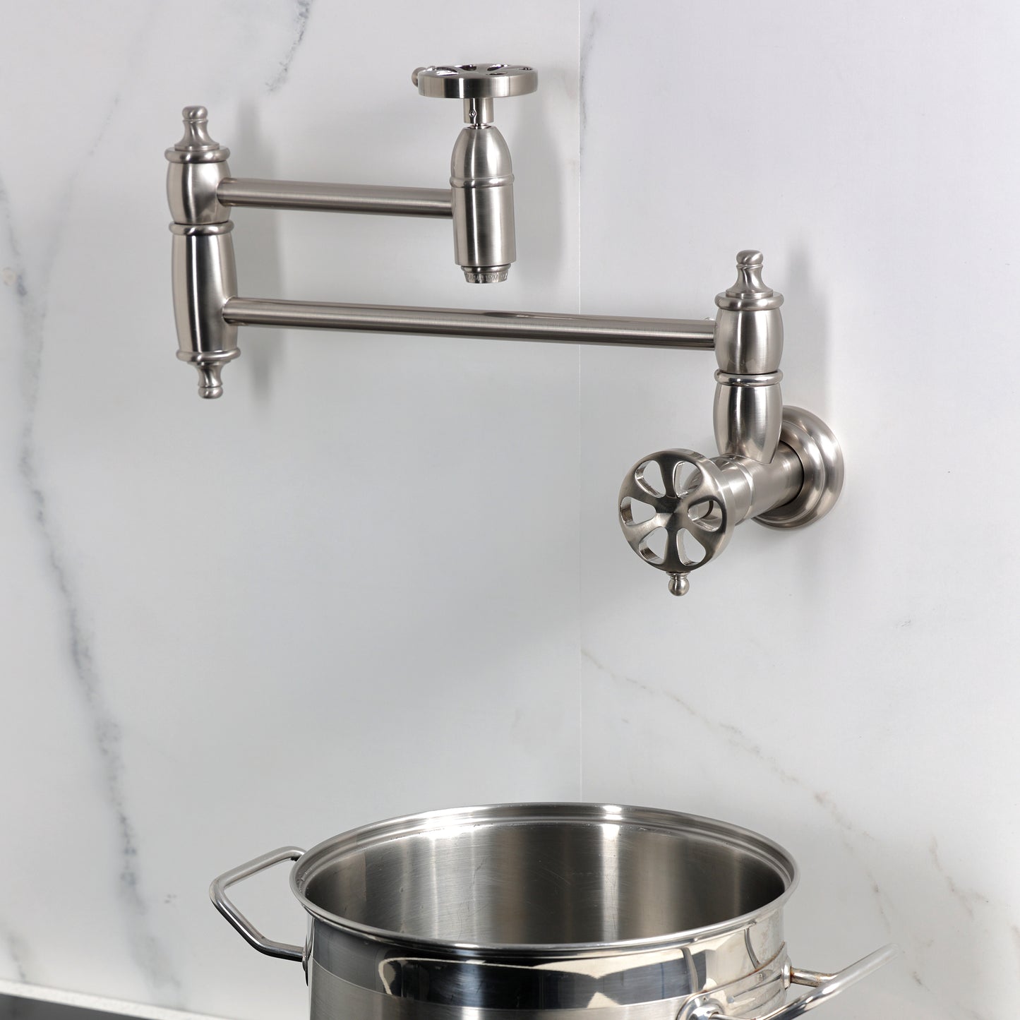 Kingston Brass KS3103RX Belknap Wall Mount Pot Filler Faucet, Antique Brass with swing arms and pot.