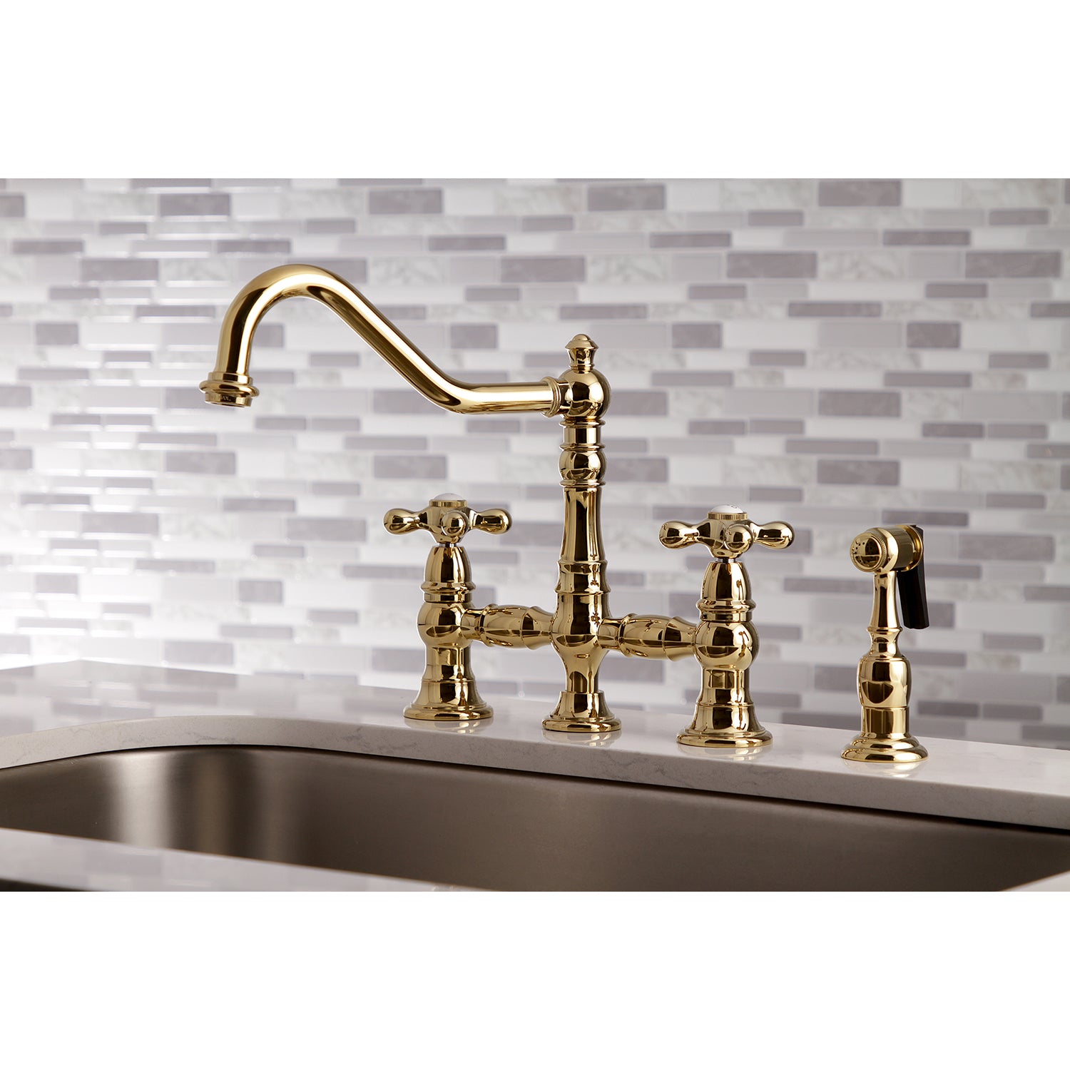 Kingston KS3277AXBS Restoration Bridge Kitchen Faucet with Brass Sprayer, Brushed Brass on decorative backsplash.