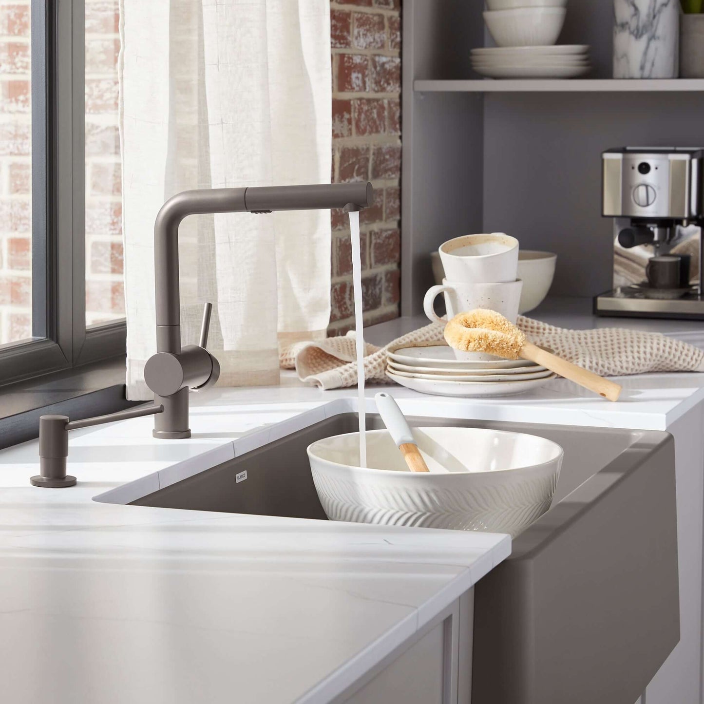 BLANCO Linus Low Arc Pull-Out Dual-Spray Kitchen Faucet - Volcano Gray in a modern kitchen setting with a sink.