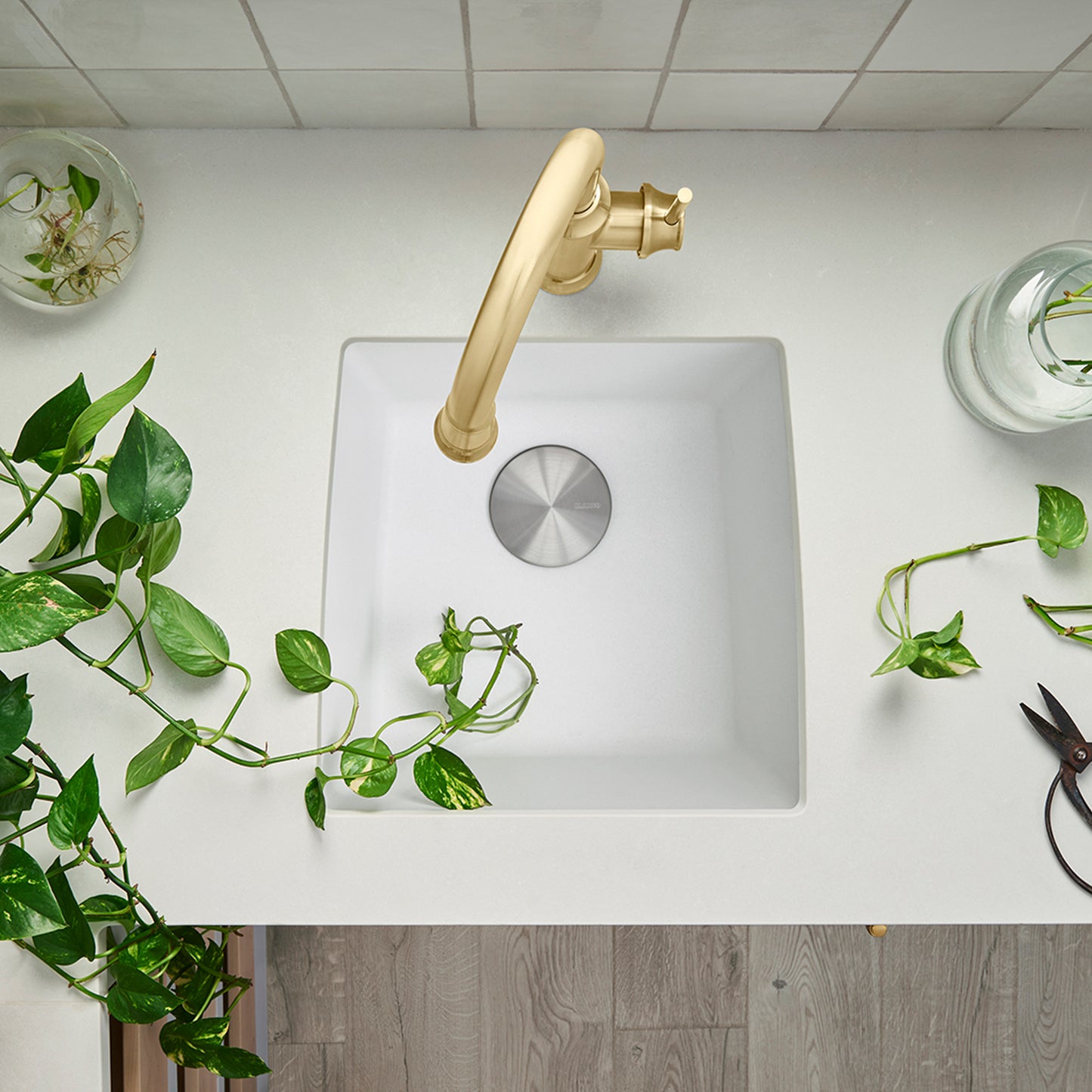 BLANCO Performa SILGRANIT 17" Undermount Bar Sink with golden faucet and green plants