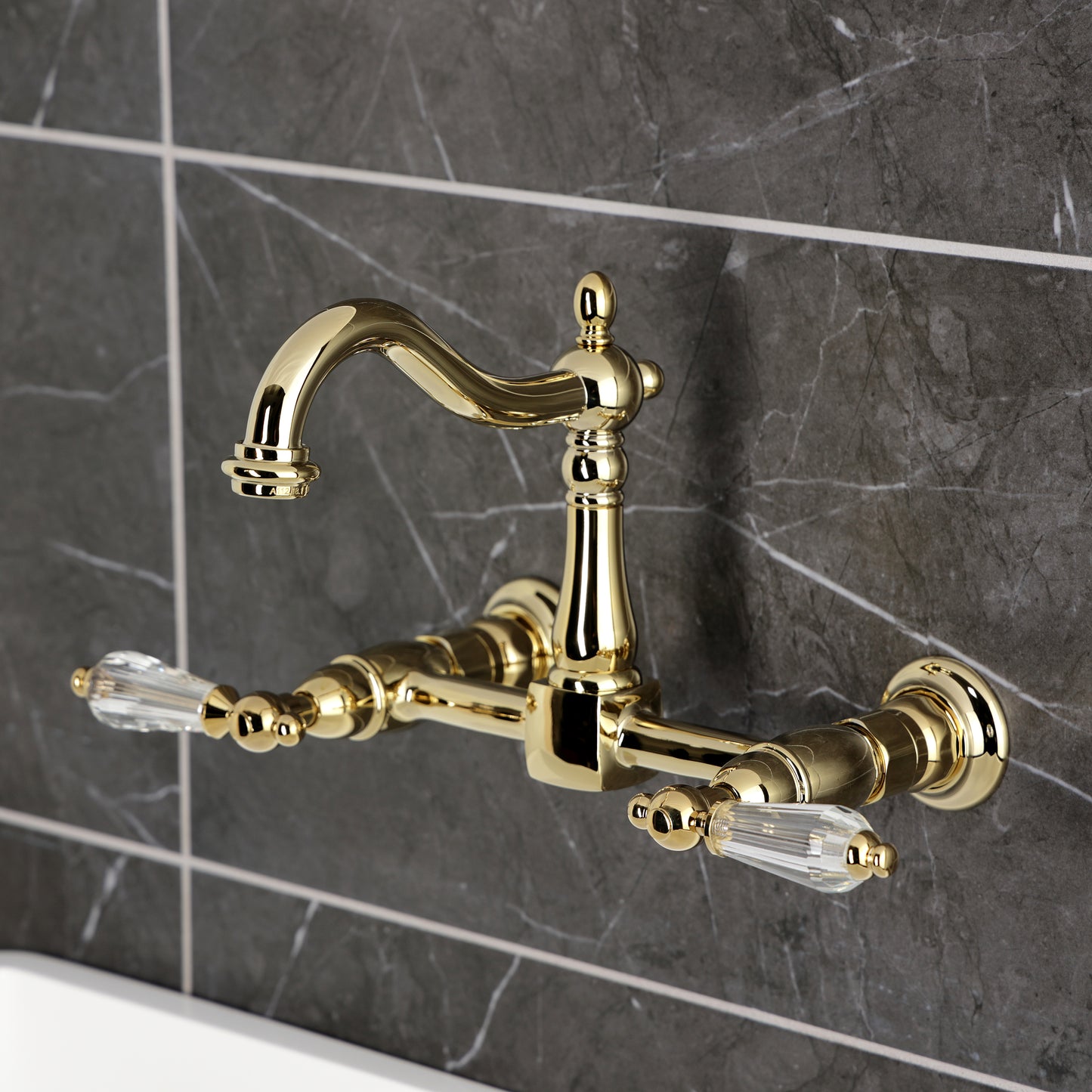 Kingston KS1263WLL Willshire Two-Handle Wall Mount Bridge Kitchen Faucet, Antique Brass on grey tiled wall.