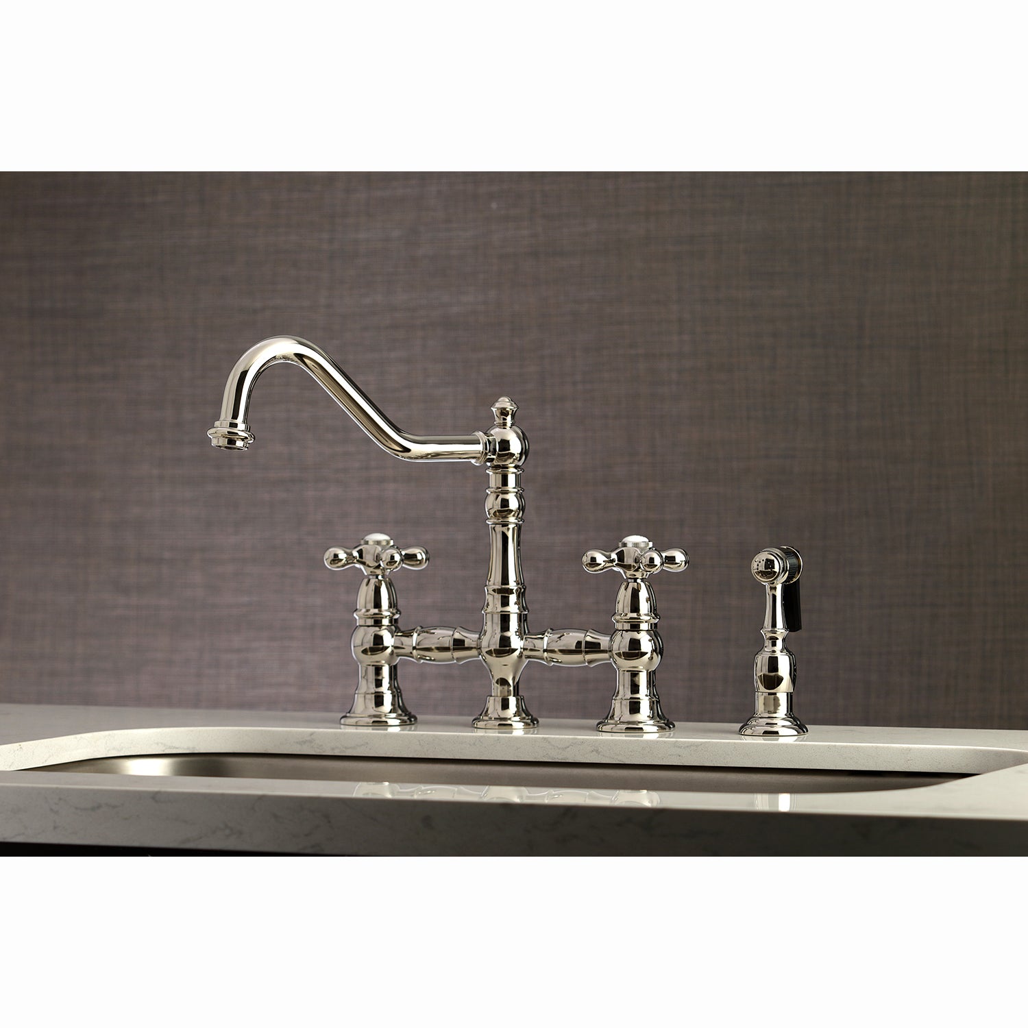 Kingston KS3277AXBS Restoration Bridge Kitchen Faucet with Brass Sprayer, Brushed Brass in a stylish kitchen setting.