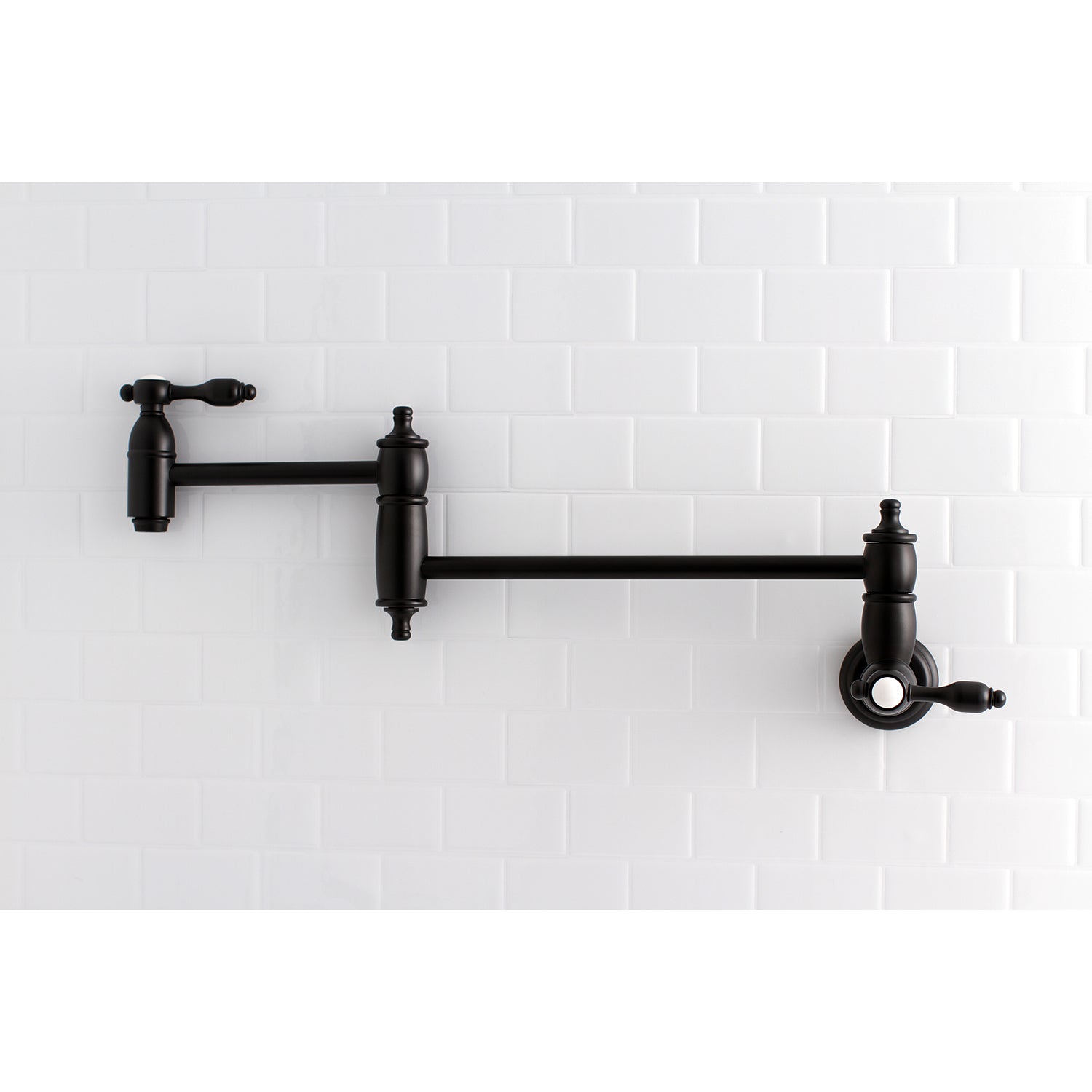 Kingston Brass KS3103TAL Tudor Wall Mount Pot Filler Faucet, Antique Brass against white subway tile backdrop.