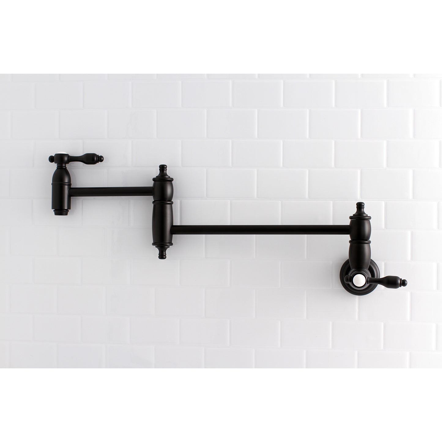 Kingston Brass KS3103TAL Tudor Wall Mount Pot Filler Faucet, Antique Brass against white subway tile backdrop.