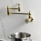 Kingston Brass KS3103CG Fuller Wall Mount Pot Filler Faucet, Antique Brass image showing elegant design and foldable swing arms.