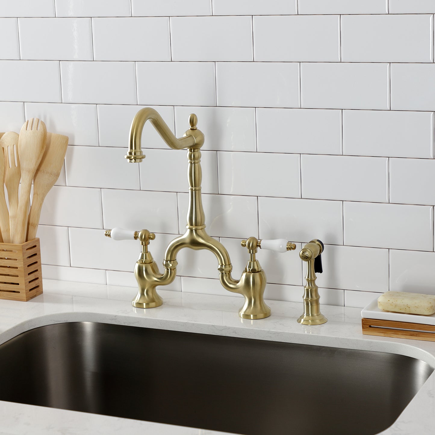 Kingston KS7753PLBS English Country Bridge Kitchen Faucet with Brass Sprayer, Antique Brass in a chic kitchen setting.