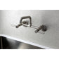Kingston Brass KS823SB Concord Wall Mount Bridge Kitchen Faucet in sleek design over a stainless steel sink.