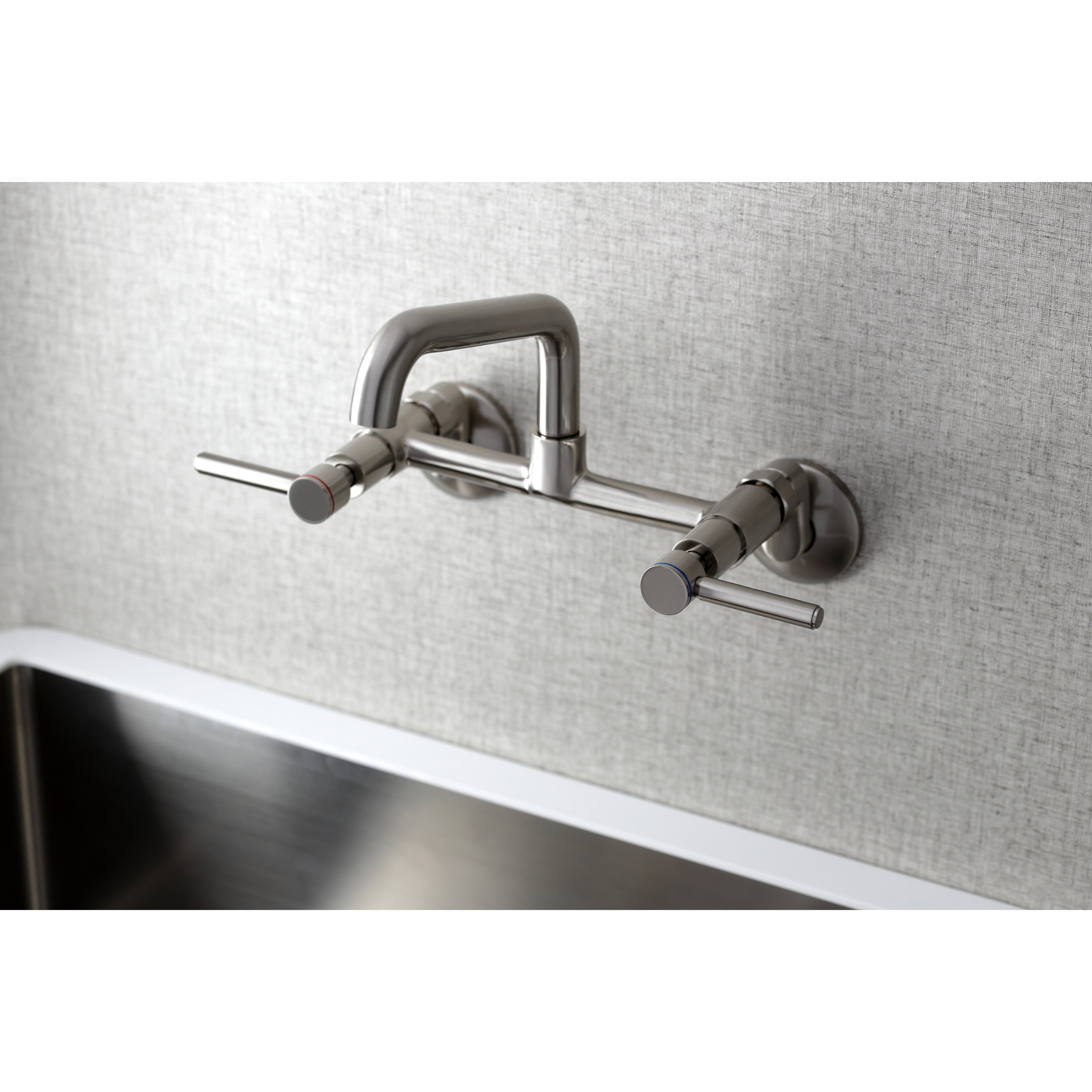 Kingston Brass KS823SB Concord Wall Mount Bridge Kitchen Faucet in sleek design over a stainless steel sink.