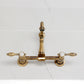 Kingston KS2443TAL Tudor Two-Handle Wall Mount Bridge Kitchen Faucet, Antique Brass on marble countertop
