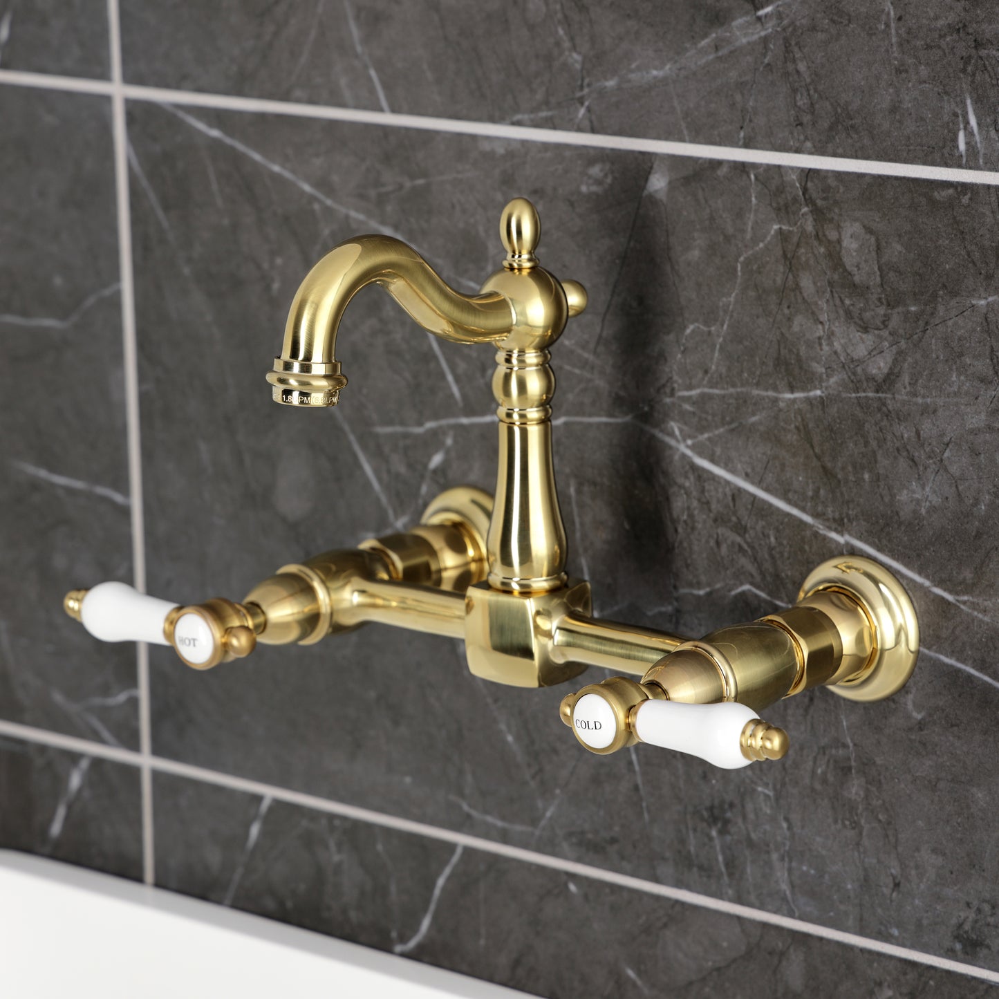 Kingston KS2443BPL Bel-Air Two-Handle Wall Mount Bridge Kitchen Faucet, Antique Brass on stylish wall tiles.