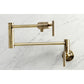 Kingston Brass KS4103CML Manhattan Wall Mount Pot Filler Faucet, Antique Brass close-up view against marble background