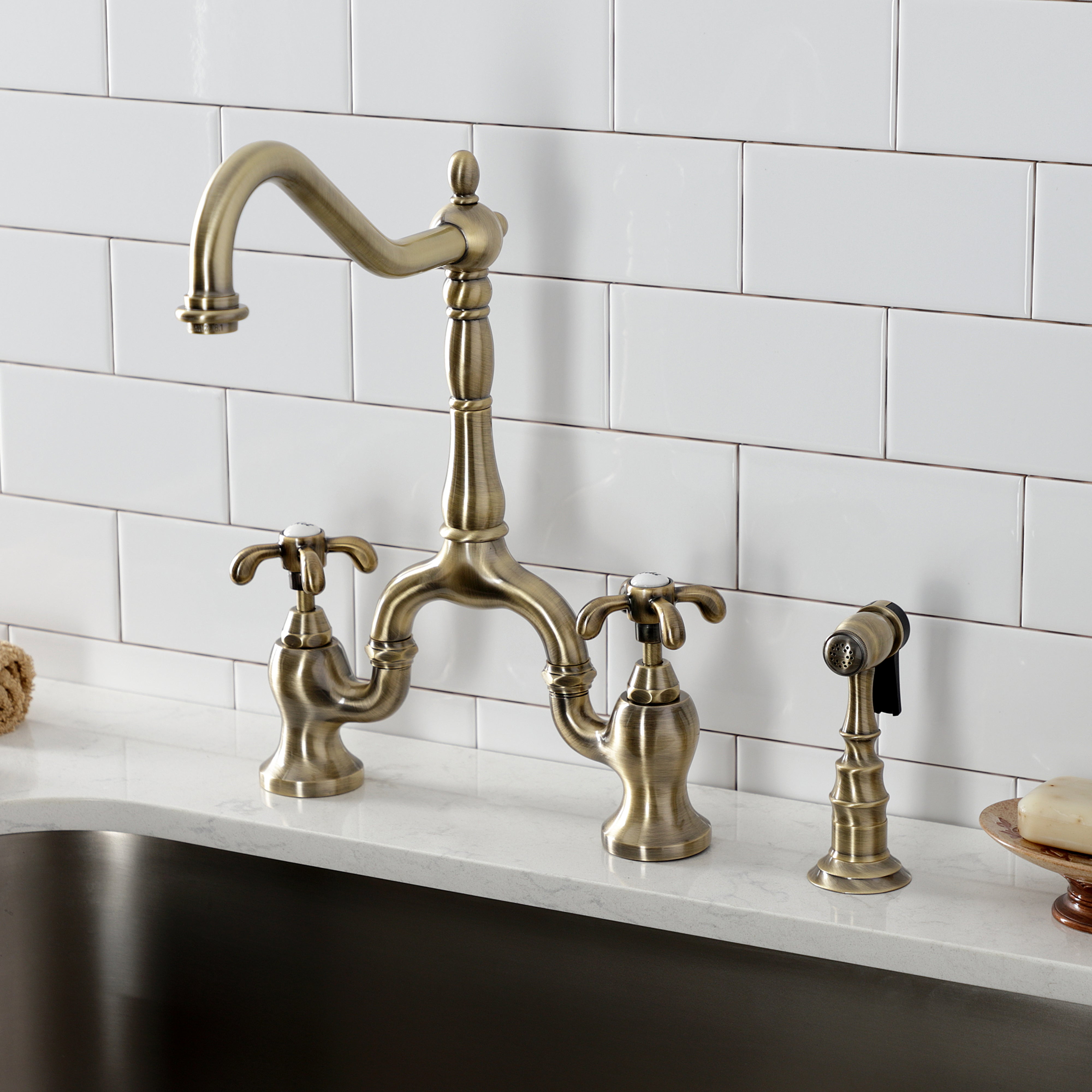 Kingston KS7753TXBS French Country Bridge Kitchen Faucet with Brass Sprayer, Antique Brass on marble countertop