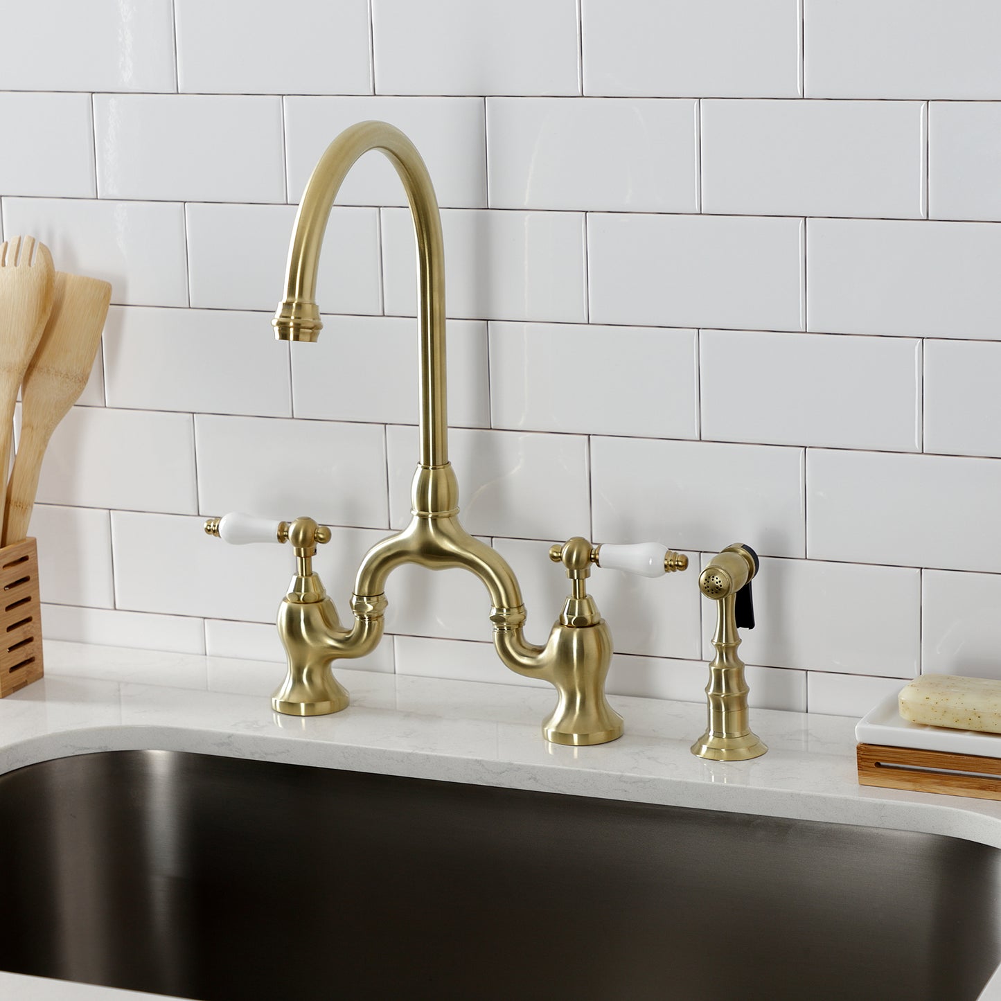 Kingston KS7793PLBS English Country Bridge Kitchen Faucet with Brass Sprayer, Antique Brass on kitchen sink.