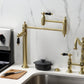 Kingston Brass KS3707PKL Duchess Deck Mount Pot Filler Faucet, Brushed Brass, featuring elegant black porcelain handles.