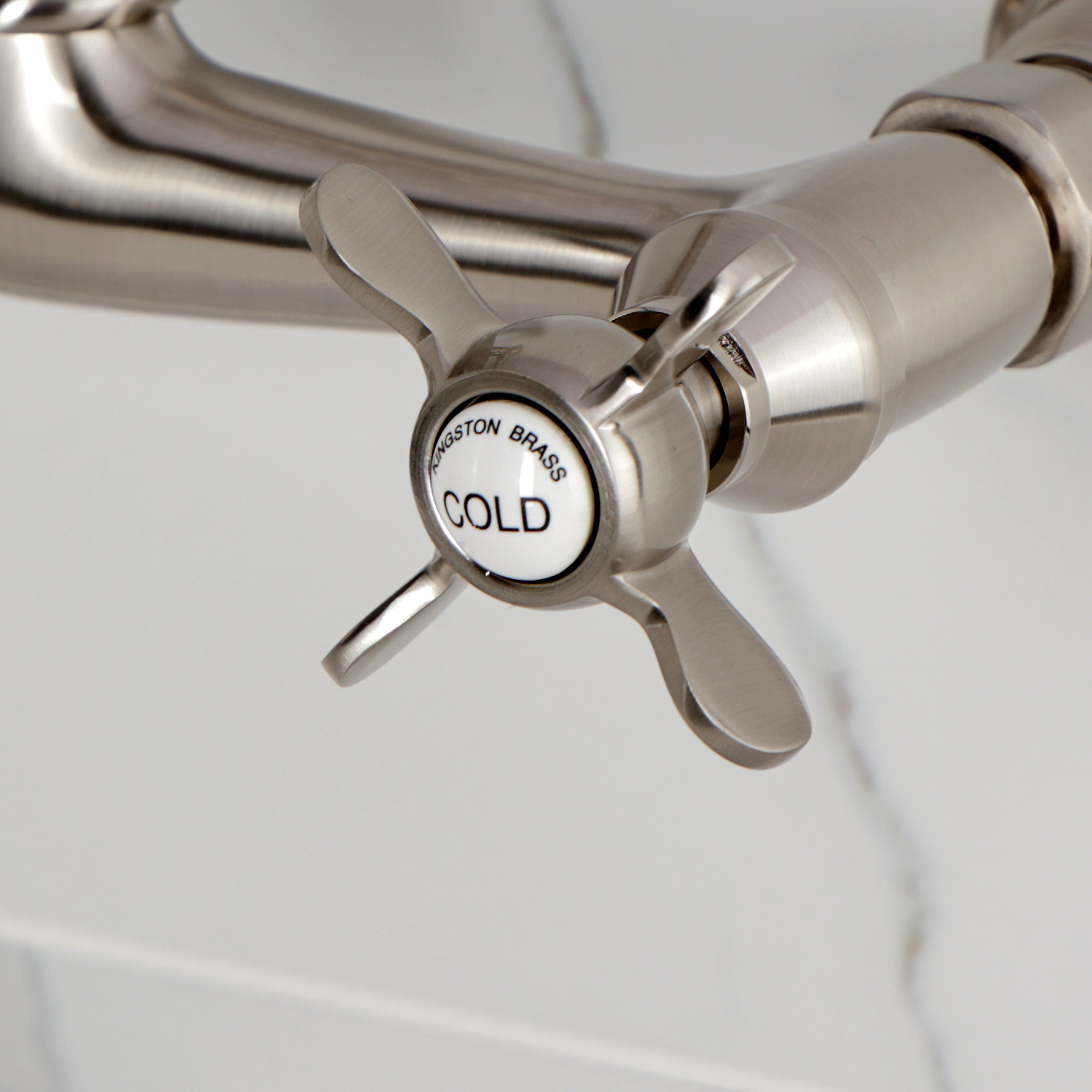 Kingston KS3253BEX Essex Two-Handle Wall Mount Bridge Kitchen Faucet, Antique Brass cold water handle close-up