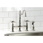 Kingston KS1273AXBS Heritage Bridge Kitchen Faucet with Brass Sprayer, Antique Brass in a modern kitchen setting.