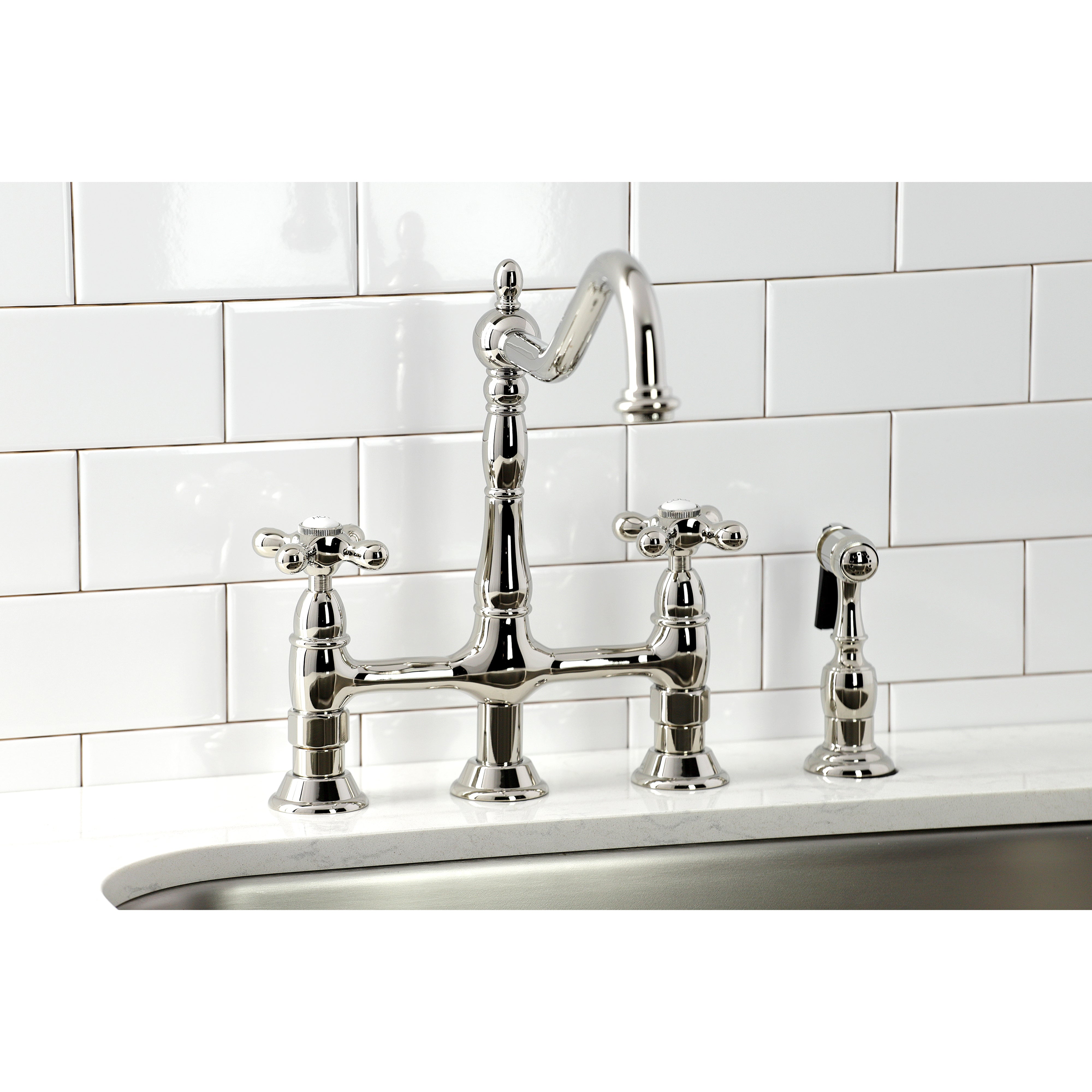 Kingston KS1273AXBS Heritage Bridge Kitchen Faucet with Brass Sprayer, Antique Brass in a modern kitchen setting.