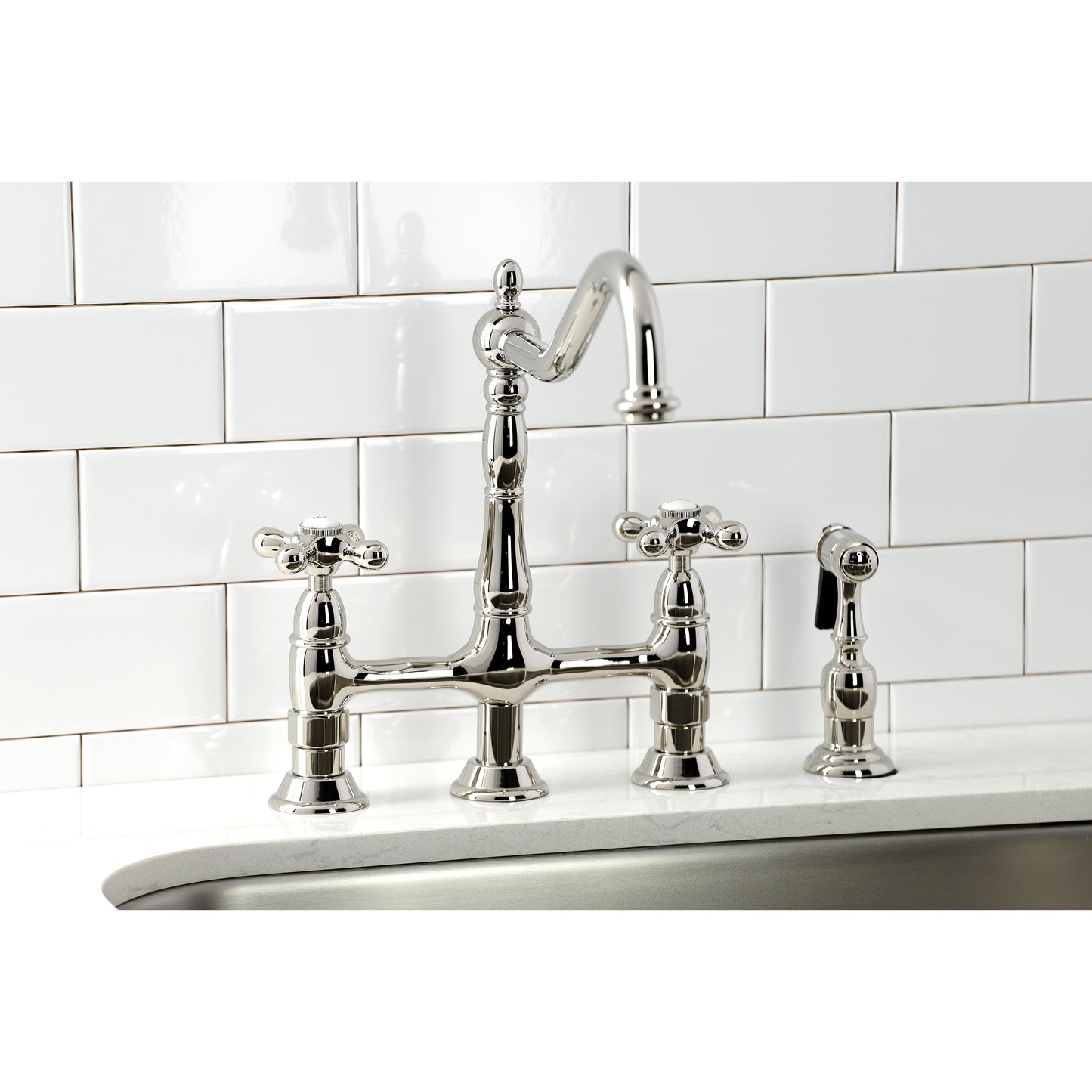 Kingston KS1273AXBS Heritage Bridge Kitchen Faucet with Brass Sprayer, Antique Brass in a modern kitchen setting.